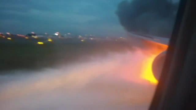 新加坡飞机起火迫降，消防车灭火，乘客从飞机内拍下过程