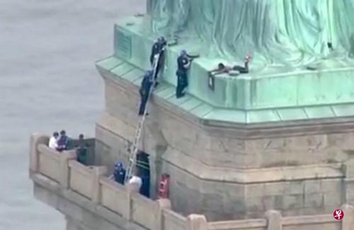 向“女神”控诉！美国独立日一女子爬上自由女神像抗议