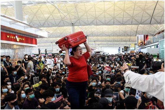 新加坡女子，香港机场高举行李箱，冲破暴徒阻碍，回家了