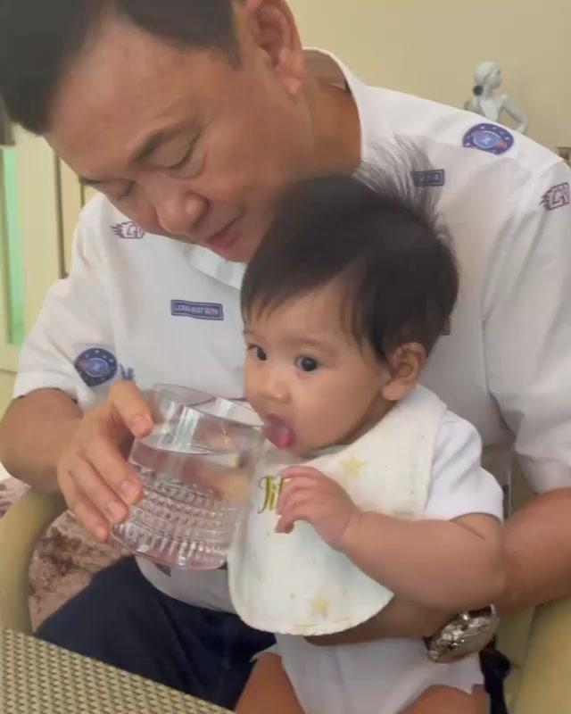 他信小女儿继续分享美好时光，姥爷给孩子喂水，孩子流口水但不喝