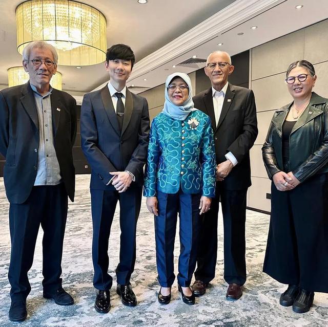 林俊杰参加新加坡国人欢聚酒会穿正装与哈莉玛总统合影